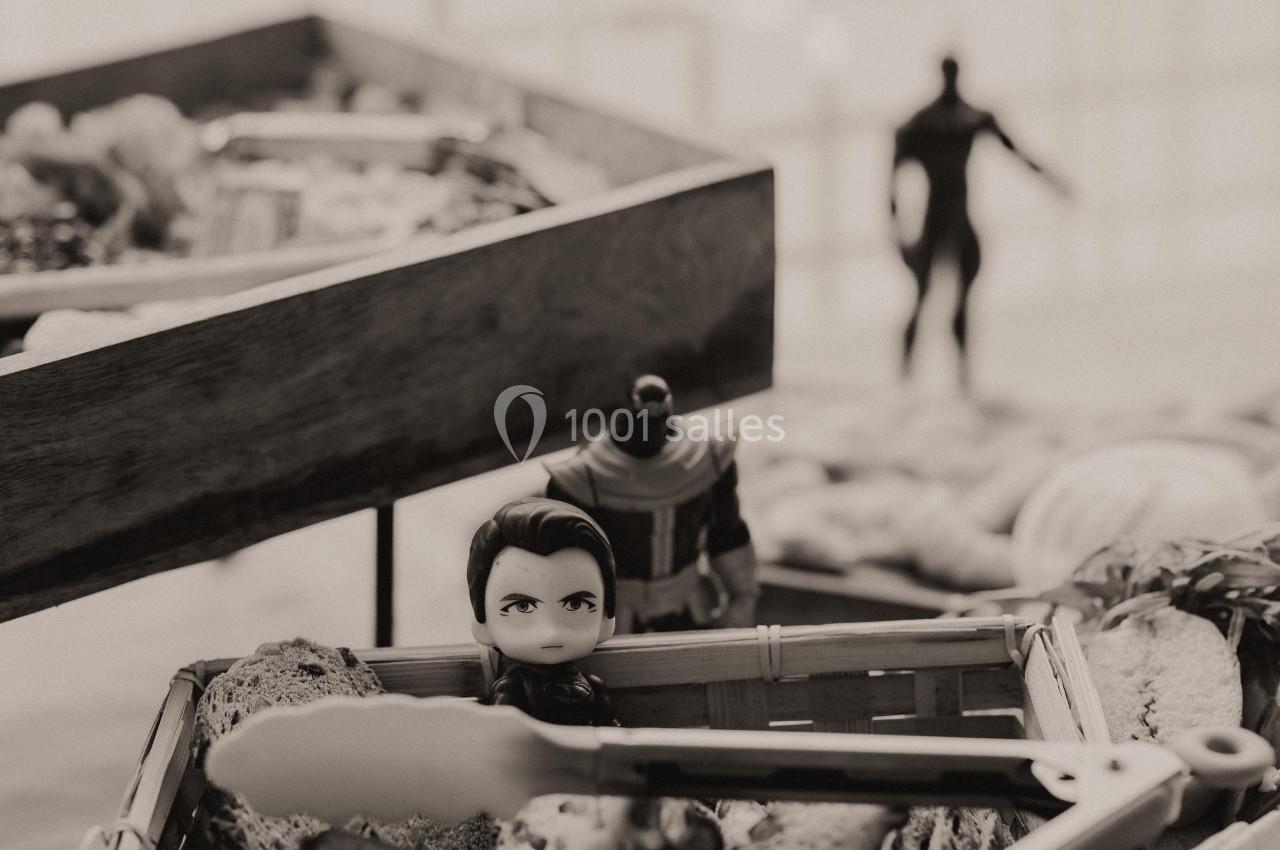 Figurines posées dans des paniers en osier, avec une autre figurine floue en arrière-plan.