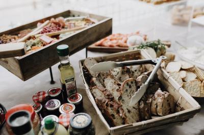 Centre de table avec bougies torsadées, fleurs colorées et nappe orange, entouré de verres et couverts.