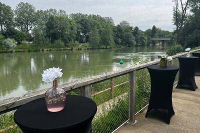 Centre de table avec bougies torsadées, fleurs colorées et nappe orange, entouré de verres et couverts.