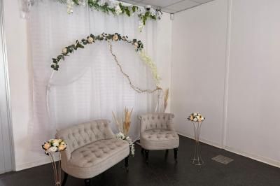 Centre de table avec bougies torsadées, fleurs colorées et nappe orange, entouré de verres et couverts.