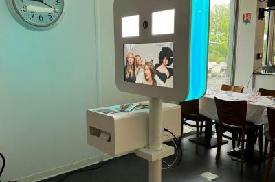 Centre de table avec bougies torsadées, fleurs colorées et nappe orange, entouré de verres et couverts.