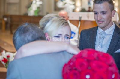 Un couple danse sous des lumières colorées dans une ambiance tamisée.