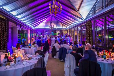 Un couple danse sous des lumières colorées dans une ambiance tamisée.