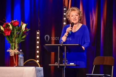 Un groupe de personnes en tenue formelle pose sur une scène lors d'un événement avec un écran affichant des logos en arrière…