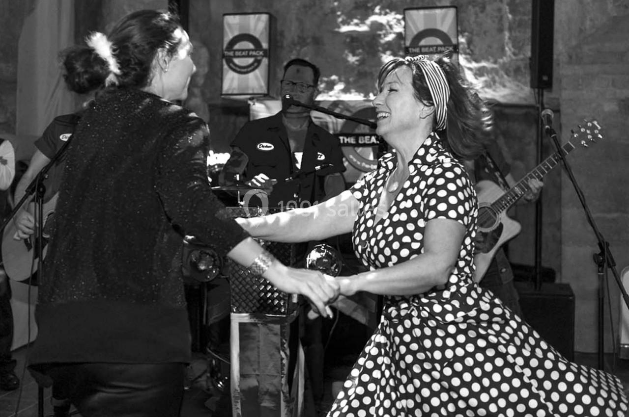 Deux femmes dansent joyeusement devant un groupe de musiciens jouant en arrière-plan.