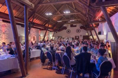 Un groupe de personnes en tenue formelle pose sur une scène lors d'un événement avec un écran affichant des logos en arrière…