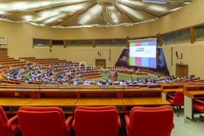 Un groupe de personnes en tenue formelle pose sur une scène lors d'un événement avec un écran affichant des logos en arrière…