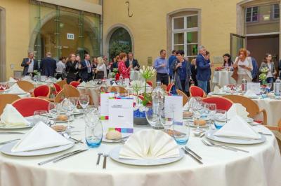 Un groupe de personnes en tenue formelle pose sur une scène lors d'un événement avec un écran affichant des logos en arrière…