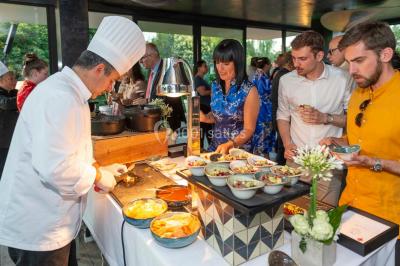 Un groupe de personnes en tenue formelle pose sur une scène lors d'un événement avec un écran affichant des logos en arrière…