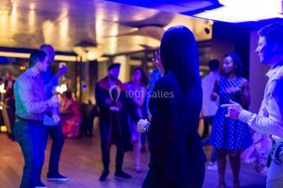 Un groupe de personnes en tenue formelle pose sur une scène lors d'un événement avec un écran affichant des logos en arrière…