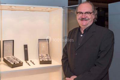 Un groupe de personnes en tenue formelle pose sur une scène lors d'un événement avec un écran affichant des logos en arrière…