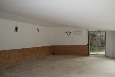 Un champ avec des vaches noires paissant, entouré de clôtures en bois et bordé d'arbres.