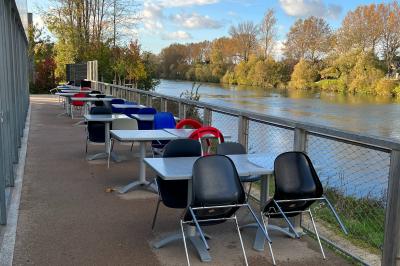 Salle de conférence lumineuse avec des participants assis, une présentation projetée et une table de buffet au premier plan.