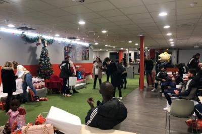 Salle de conférence lumineuse avec des participants assis, une présentation projetée et une table de buffet au premier plan.