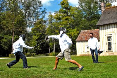 Un groupe de personnes souriantes pose dans une salle avec des rameurs et un écran projeté en arrière-plan.
