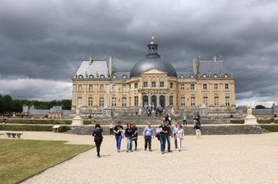 Un groupe de personnes souriantes pose dans une salle avec des rameurs et un écran projeté en arrière-plan.