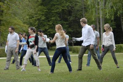 Un groupe de personnes souriantes pose dans une salle avec des rameurs et un écran projeté en arrière-plan.