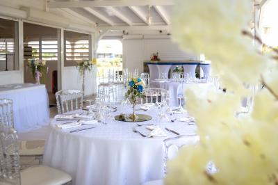 Table décorée avec des fleurs blanches, des ornements royaux ’Queen’ et ’King’, et un fond scintillant.