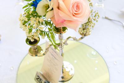 Table décorée avec des fleurs blanches, des ornements royaux ’Queen’ et ’King’, et un fond scintillant.