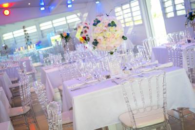 Table décorée avec des fleurs blanches, des ornements royaux ’Queen’ et ’King’, et un fond scintillant.