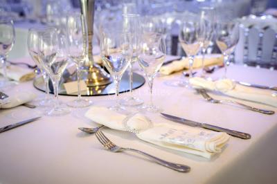 Table décorée avec des fleurs blanches, des ornements royaux ’Queen’ et ’King’, et un fond scintillant.