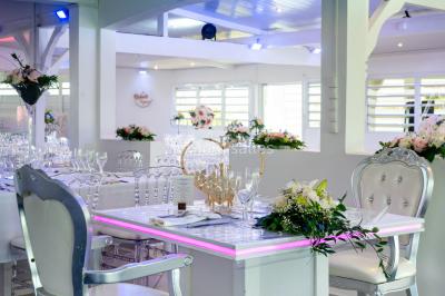 Table décorée avec des fleurs blanches, des ornements royaux ’Queen’ et ’King’, et un fond scintillant.