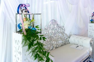 Table décorée avec des fleurs blanches, des ornements royaux ’Queen’ et ’King’, et un fond scintillant.
