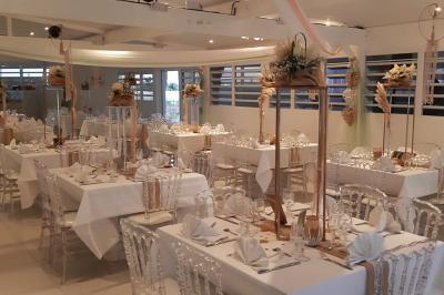 Table décorée avec des fleurs blanches, des ornements royaux ’Queen’ et ’King’, et un fond scintillant.