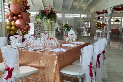 Table décorée avec des fleurs blanches, des ornements royaux ’Queen’ et ’King’, et un fond scintillant.