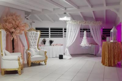 Table décorée avec des fleurs blanches, des ornements royaux ’Queen’ et ’King’, et un fond scintillant.