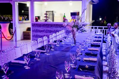 Table décorée avec des fleurs blanches, des ornements royaux ’Queen’ et ’King’, et un fond scintillant.