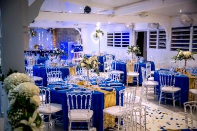 Table décorée avec des fleurs blanches, des ornements royaux ’Queen’ et ’King’, et un fond scintillant.