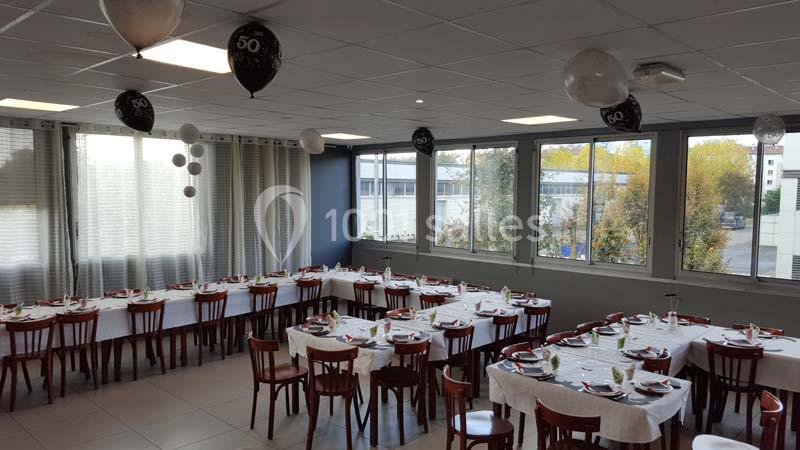 Location salle Bonneuil-sur-Marne (Val-de-Marne) - Salle des Petits Carreaux #14 Salle décorée pour un 50e anniversaire, avec des tables dressées et des ballons noirs et blancs suspendus.