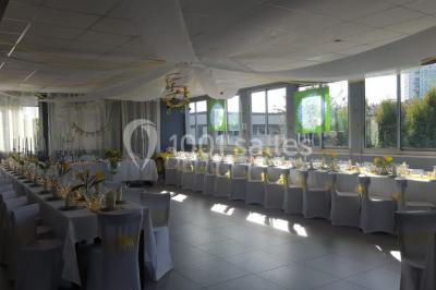 Miniature Location salle Bonneuil-sur-Marne (Val-de-Marne) - Salle des Petits Carreaux #16 Salle de réception lumineuse avec tables dressées, nappes blanches et serviettes bleues, prête pour un événement.