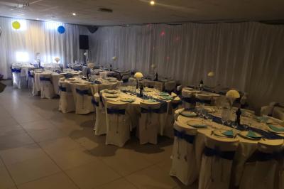 Miniature Location salle Bonneuil-sur-Marne (Val-de-Marne) - Salle des Petits Carreaux #5 Salle de réception lumineuse avec tables dressées, nappes blanches et serviettes bleues, prête pour un événement.