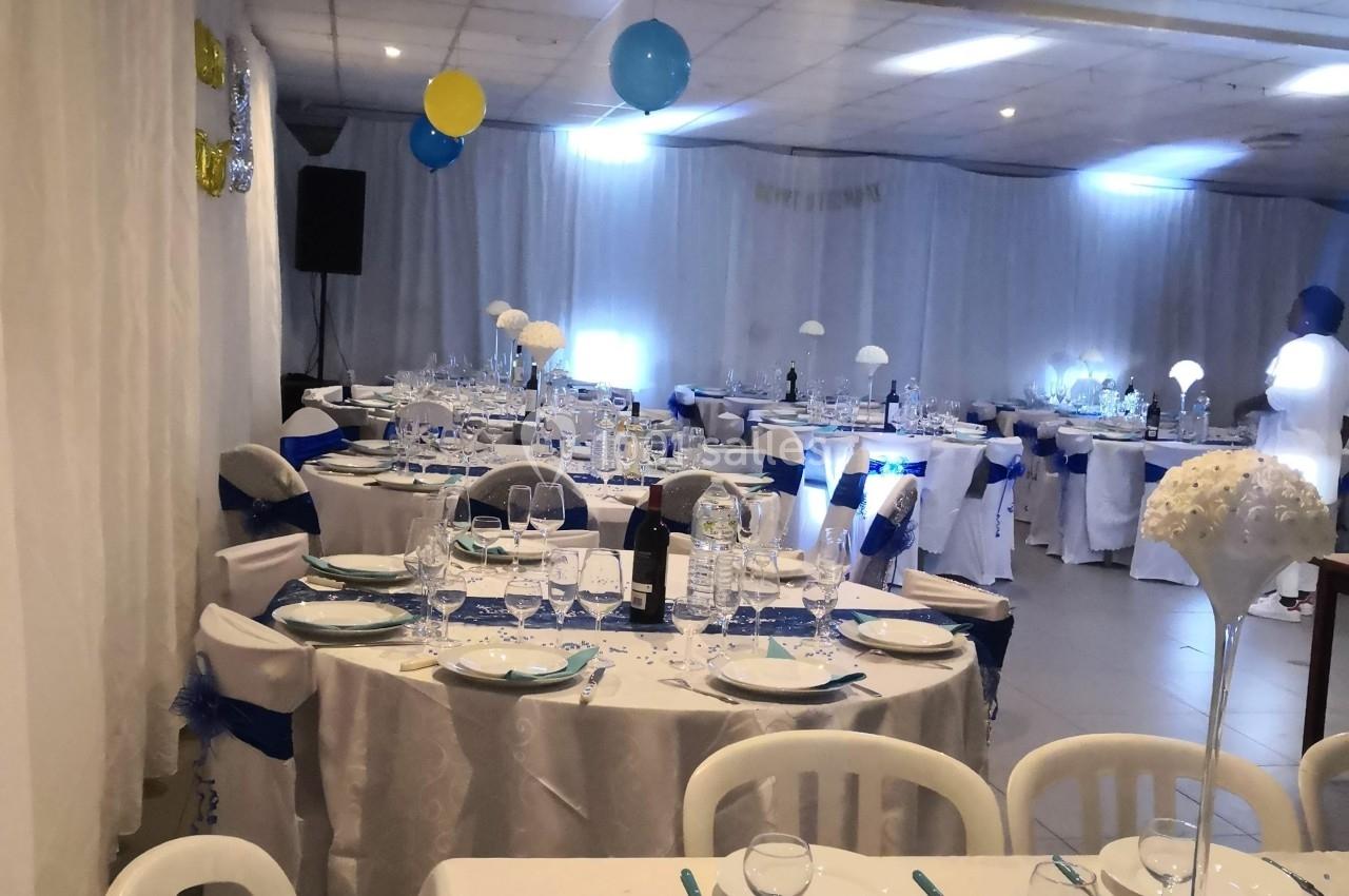 Location salle Bonneuil-sur-Marne (Val-de-Marne) - Salle des Petits Carreaux #4 Salle décorée pour un événement avec tables dressées, nappes blanches, chemins de table bleus et ballons suspendus.