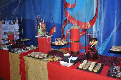 Des personnes dansent sous des éclairages colorés dans une salle sombre avec des sièges en arrière-plan.