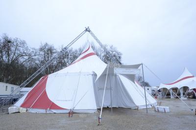 File d'attente devant un chapiteau de cirque blanc avec un guichet de billetterie sur la gauche.
