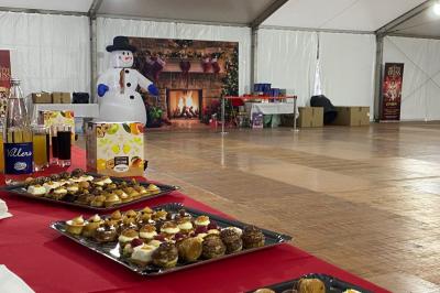 File d'attente devant un chapiteau de cirque blanc avec un guichet de billetterie sur la gauche.