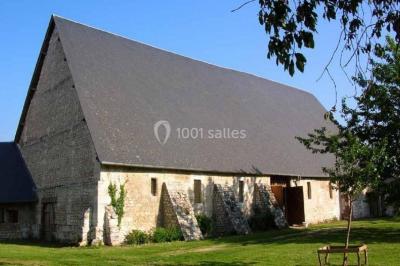 Voiture ancienne noire décorée de fleurs, stationnée sur une allée pavée dans un cadre champêtre.