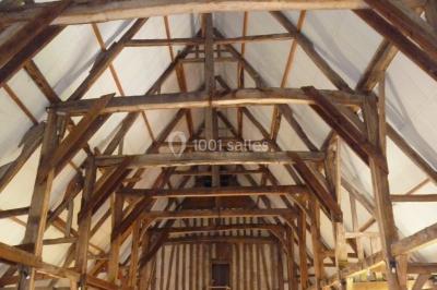 Voiture ancienne noire décorée de fleurs, stationnée sur une allée pavée dans un cadre champêtre.