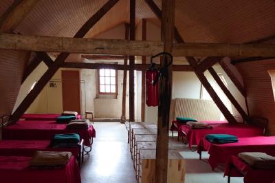 Voiture ancienne noire décorée de fleurs, stationnée sur une allée pavée dans un cadre champêtre.