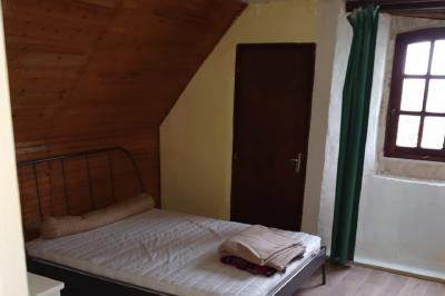 Voiture ancienne noire décorée de fleurs, stationnée sur une allée pavée dans un cadre champêtre.