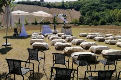 Salle de réception avec tables dressées, nappes blanches, chaises décorées et éclairage naturel à travers de grandes…