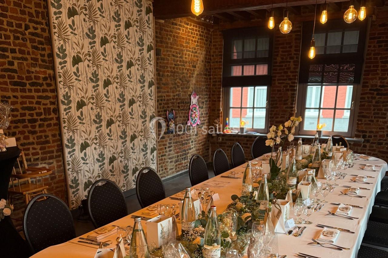 Traiteur Forest-sur-Marque (Nord) - Auberge du Tilleul #17 Table dressée pour un repas festif dans une salle en briques avec éclairage suspendu et décoration végétale.