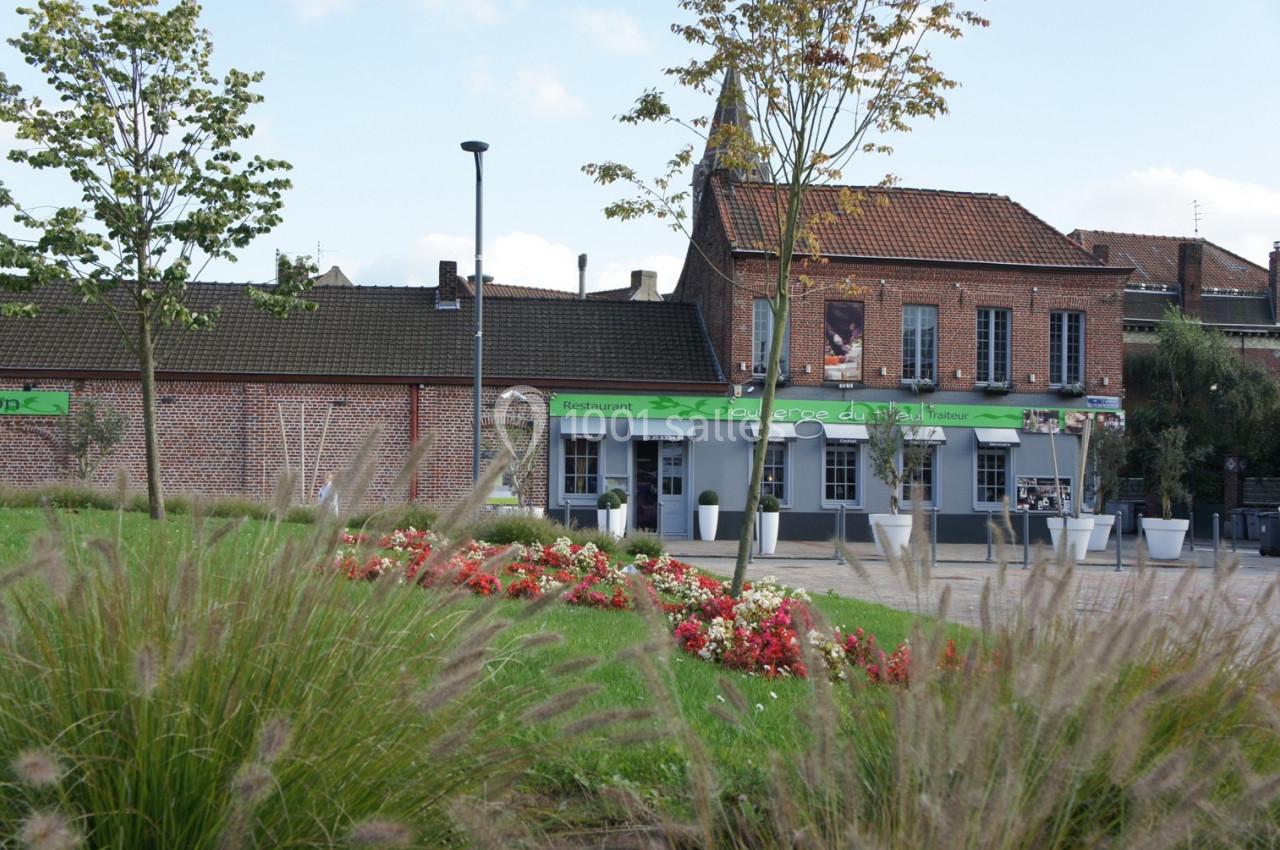 LE JARDIN DES PERSPECTIVES POUR VOS PHOTOS FACE A L AUBERGE DU TILLEUL Façade d'un restaurant en briques rouges avec terrasse, entourée de parterres fleuris et d'arbres.