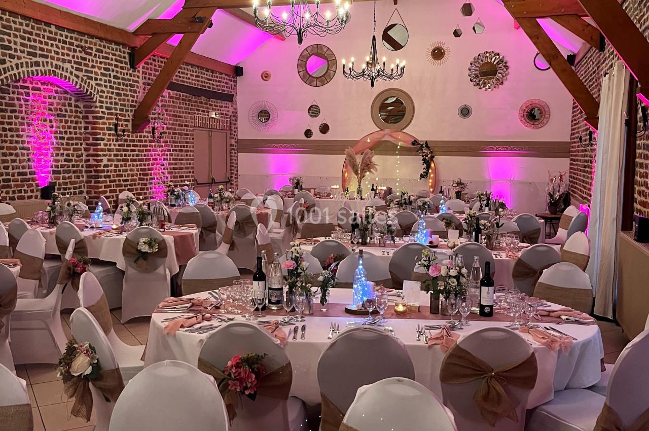 SALON GAUGUIN Nouvelle déco Salle de réception décorée pour un événement, avec tables dressées, nappes blanches et éclairage rose.