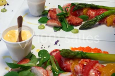 Dessert roulé recouvert de glaçage rouge, garni de rondelles de banane, avec des touches de coulis sur l'assiette blanche.