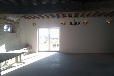 Chambre mansardée avec deux lits simples, un bureau en bois, une chaise blanche et une fenêtre de toit.