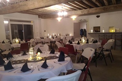 Chambre mansardée avec deux lits simples, un bureau en bois, une chaise blanche et une fenêtre de toit.